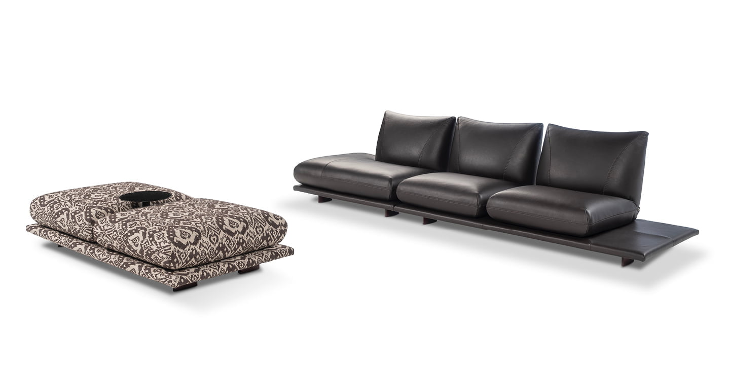 PRALIN Modular 'Pralin' sofa with removable elements, wooden feet, and versatile configurations, including a day bed and integrated table, ensures customizable comfort and relaxation.
